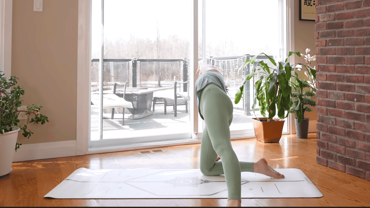 Yoga With Kassandra practicing yoga stretches during 20-minute morning yoga