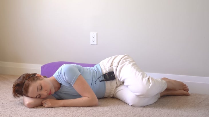 woman practicing yoga near a wall on her side