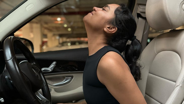 woman practicing yoga in her car tilting backwards