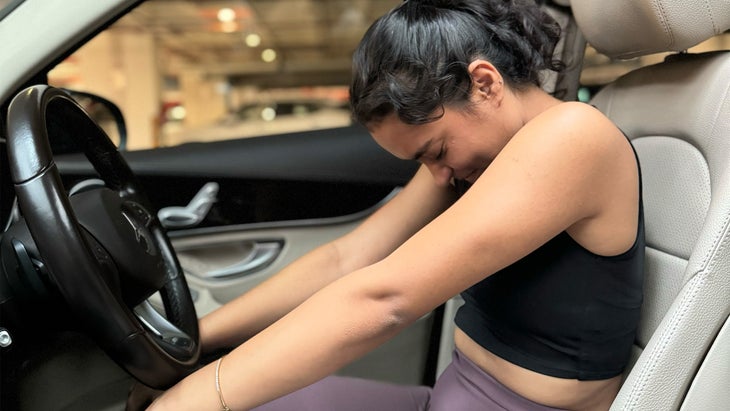 woman practicing yoga in her car arching her back