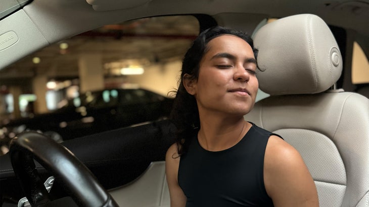 woman practicing yoga in her car turning her chin over her left shoulder