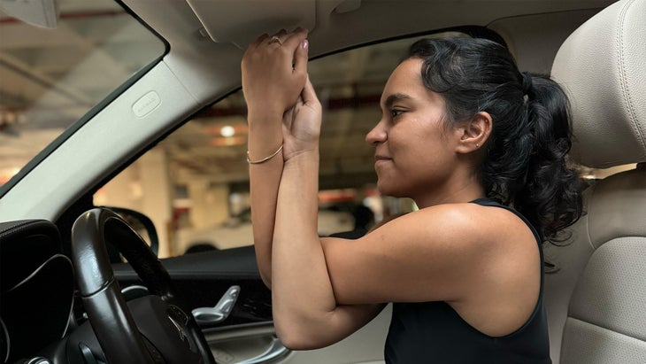 woman practicing yoga in her car crossing her arms