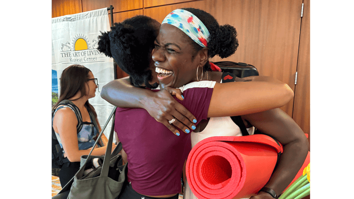 Women yoga students and teachers hugging at the Dirty South Yoga Fest.