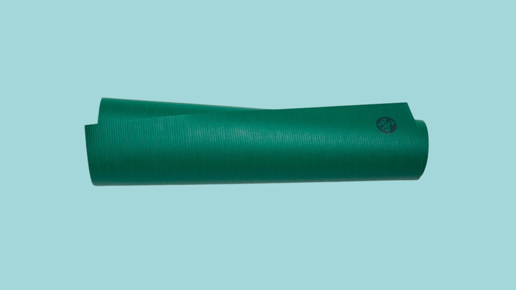 A rolled green yoga mat from Manduka