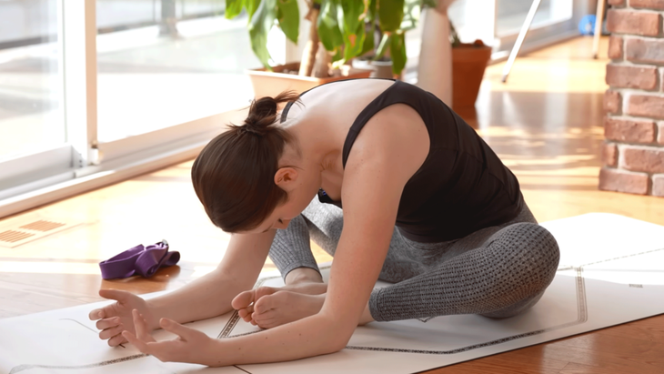 Yoga With Kassandra sitting on a yoga mat practicing Bound Angle or Butterfly Pose