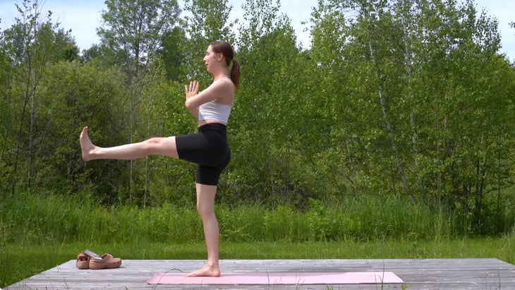 woman outdoors on a yoga mat practicing a yoga flow