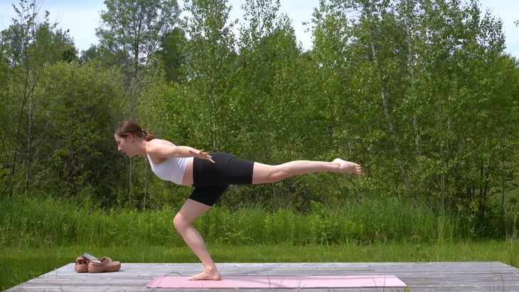 woman outdoors on a yoga mat practicing a 15-minute morning yoga class