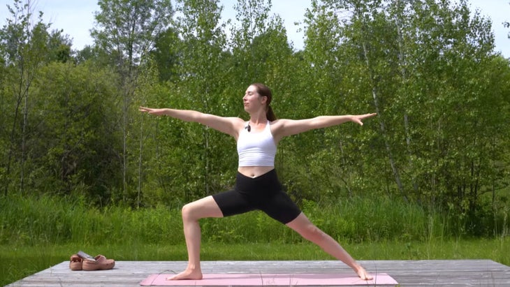 woman outdoors on a yoga mat practicing a yoga flow