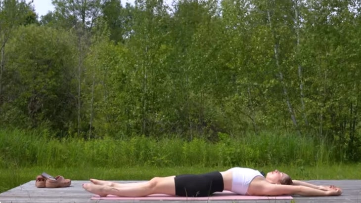 woman outdoors on a yoga mat during a 15-minute morning yoga practice