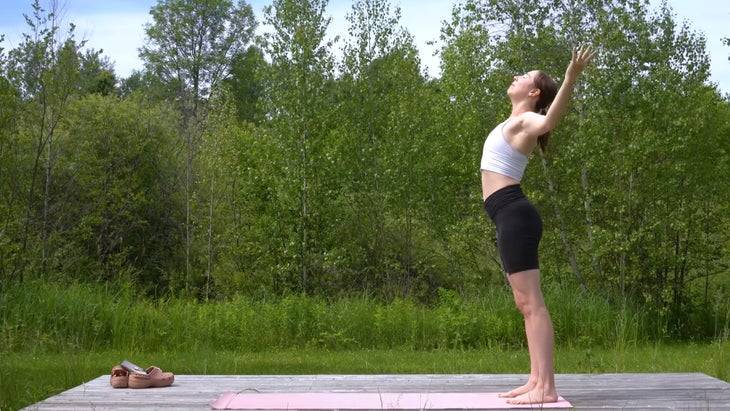 woman outdoors on a yoga mat practicing a yoga flow