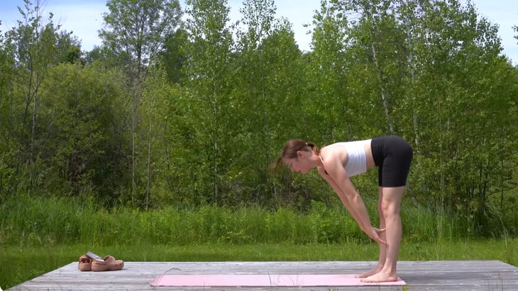 woman outdoors on a yoga mat in the middle of a yoga flow