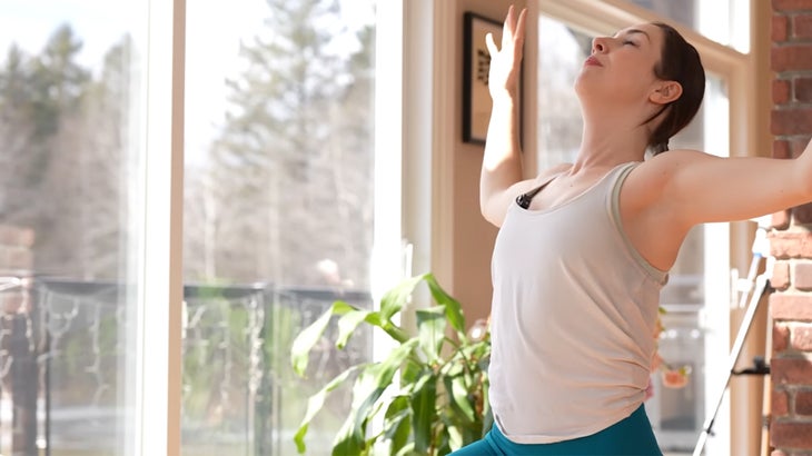 Woman on a yoga mat practicing a 15-minute yoga flow without using her hands