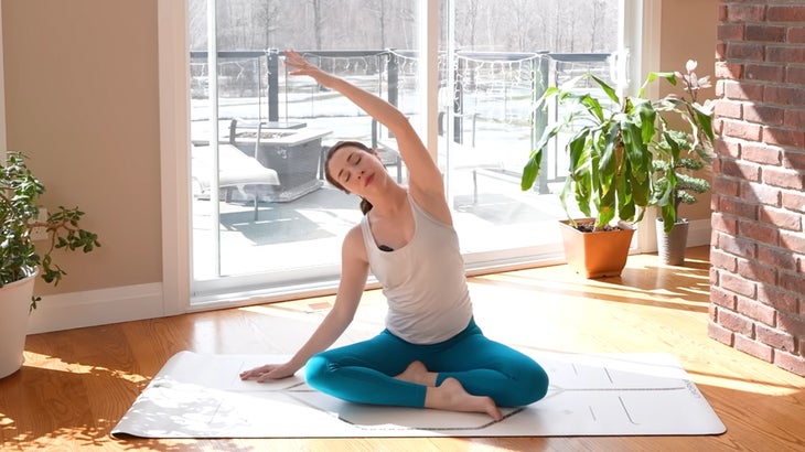 Woman on a yoga mat practicing a 15-minute yoga flow without using her hands