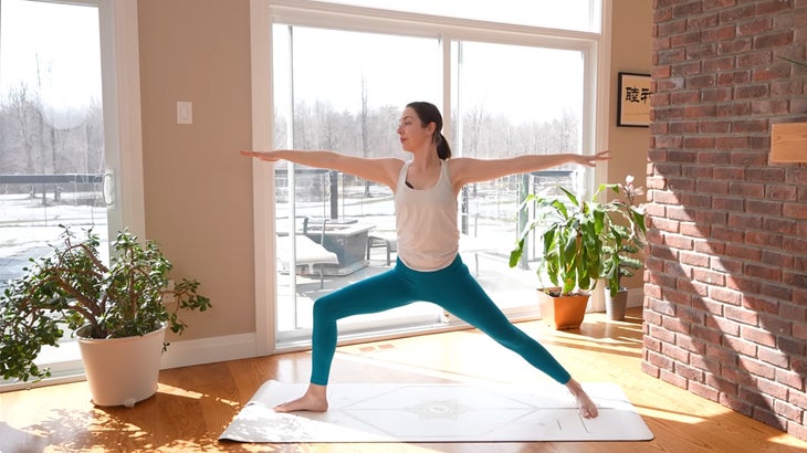 Woman on a yoga mat practicing a 15-minute yoga flow without using her hands