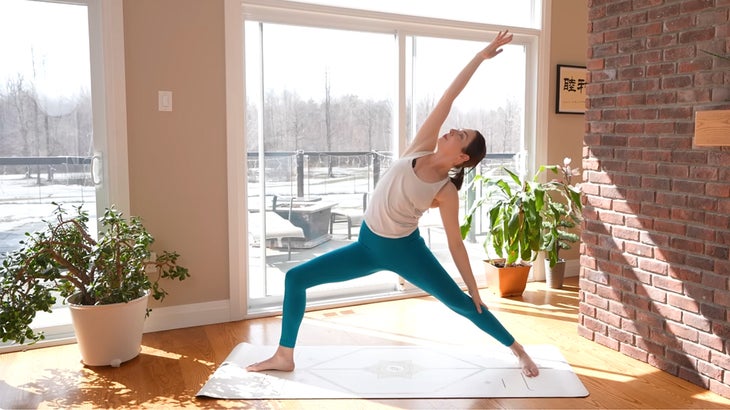 Woman on a yoga mat practicing a 15-minute yoga flow without using her hands