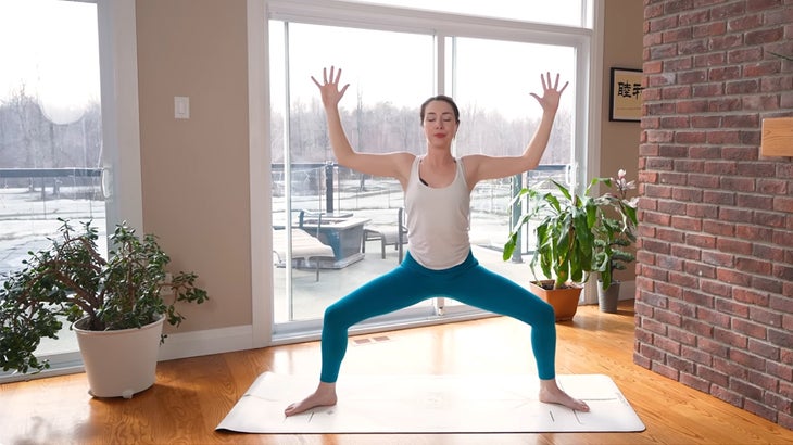 Woman on a yoga mat practicing a 15-minute yoga flow without using her hands