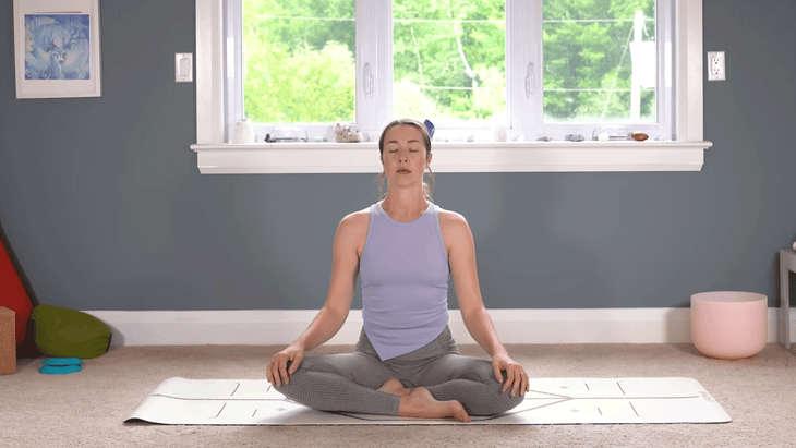 Woman sitting cross-legged on a yoga mat