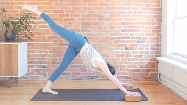 Woman on a yoga mat learning how to move from the back of the mat to the front in a single step