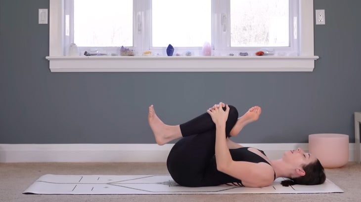 woman on a yoga mat does a morning practice