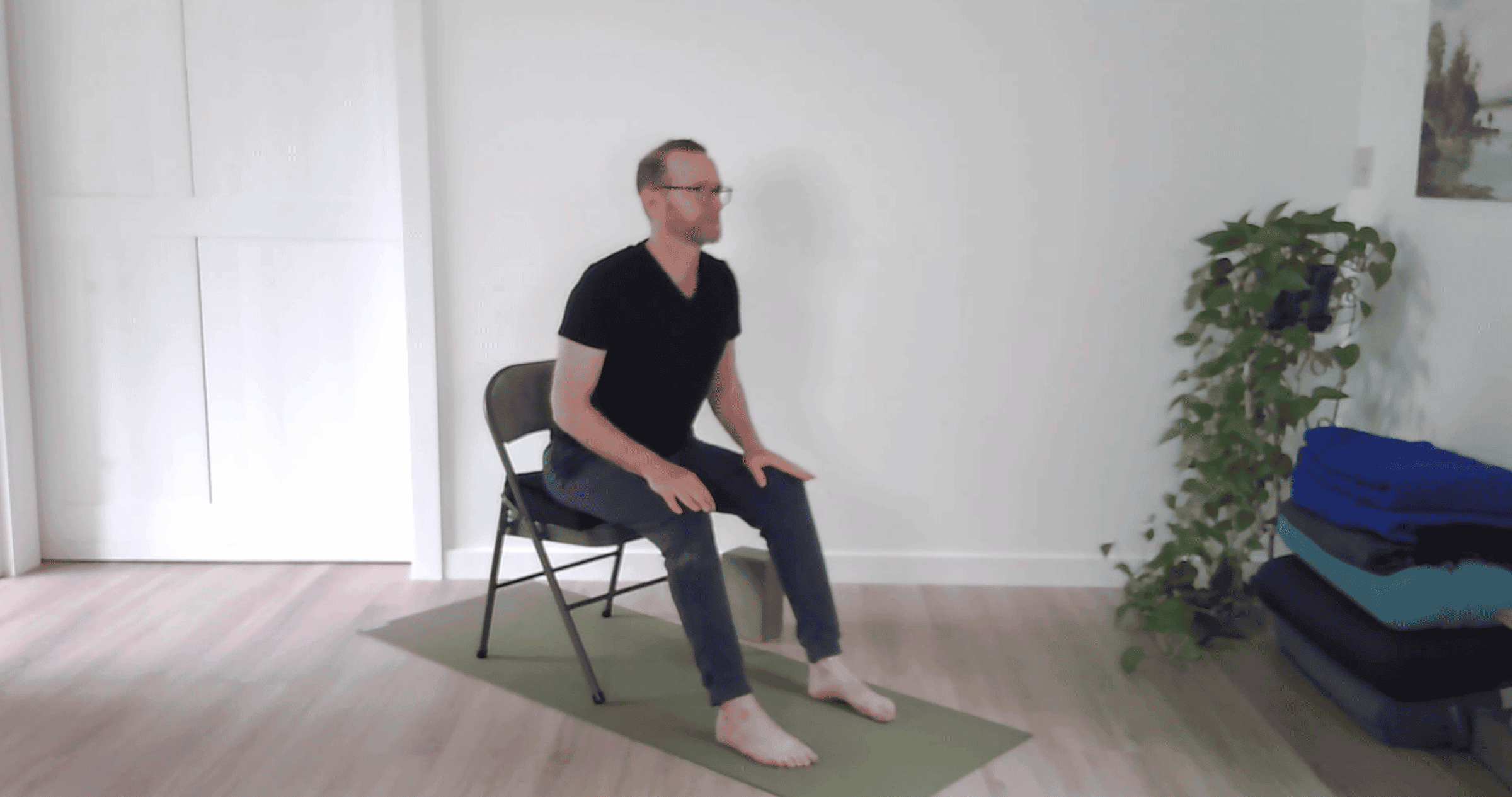 Man practicing a slight backbend in a chair