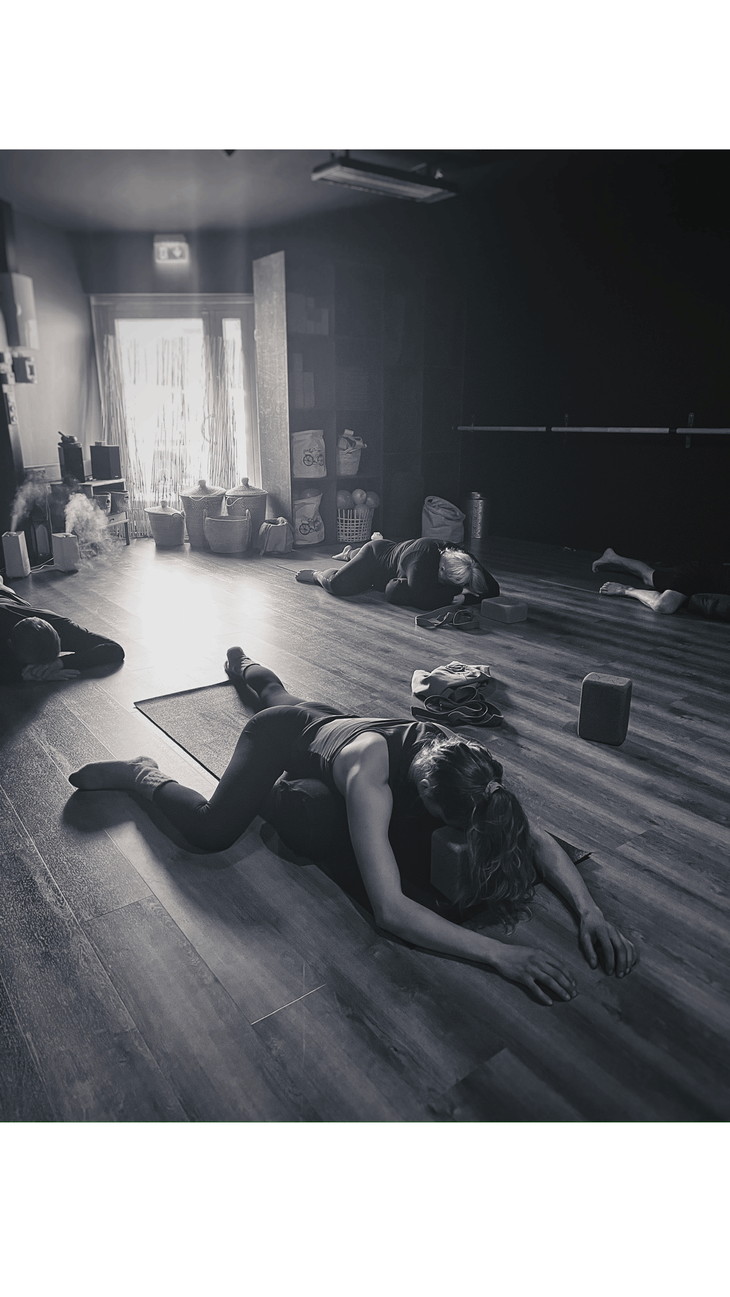 Black and whilte photo of a woman in a yin yoga pose named Lazy or Resting Frog