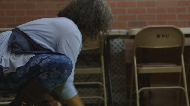 Instructora de yoga femenina extendiendo una esterilla de yoga