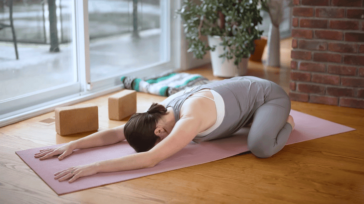 Woman in Child's Pose on a yoga mat