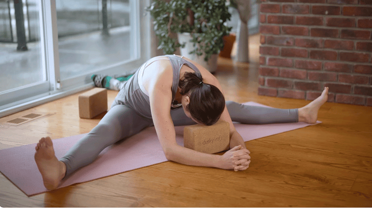 Woman in the yin yoga pose known as Straddle on a yoga mat