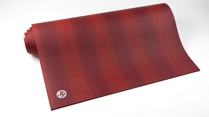 A partially unrolled yoga mat with red stripes