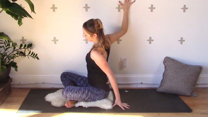 woman practicing yin yoga with a wall