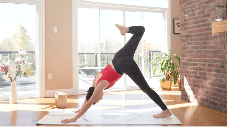 woman in three-legged dog on a yoga mat