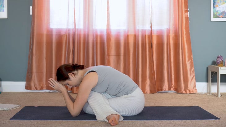 woman practicing yin yoga and setting intentions on a yoga mat