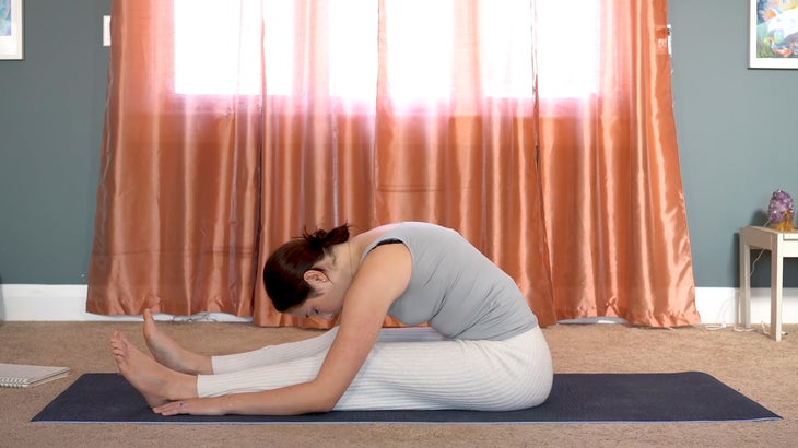 woman practicing yin yoga and setting intentions on a yoga mat