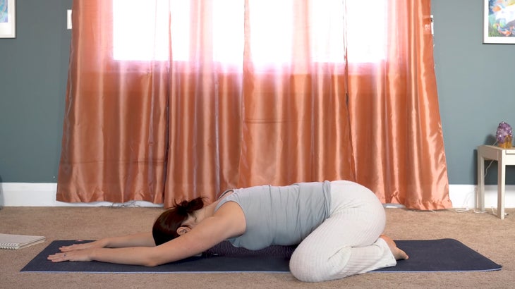 woman practicing yin yoga and setting intentions on a yoga mat