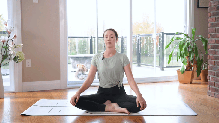 Woman sitting on a yoga mat practicing seated meditation