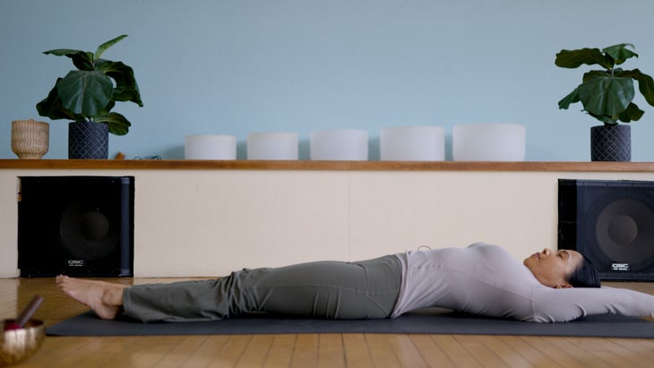 Woman lying on a yoga mat with her arms and legs extended