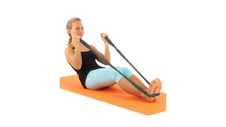 Image of woman on orange yoga mat with Mat Strap Plus wrapped around feet and holding ends of the strap in both hands.