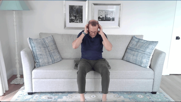 Man sitting on a couch doing a crunch