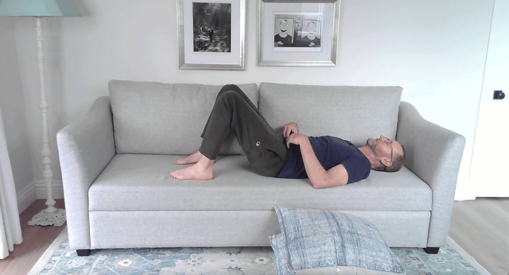 Man on a couch practicing subtle back movements