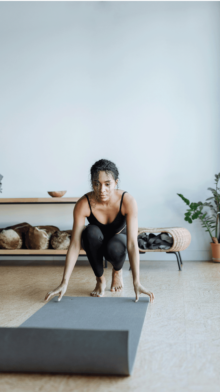 Woman unrolling a yoga mat quietly in a class so as not to disrupt others