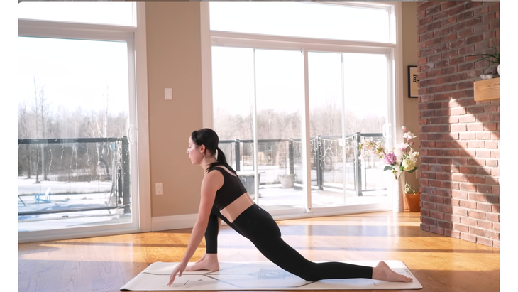 Woman kneeling on a yoga mat in Low Lungee