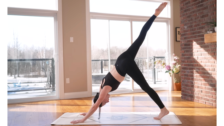 Woman practicing Three-Legged Dog on a yoga mat