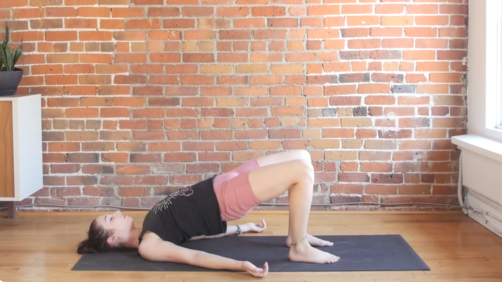 Woman lying on her back in Bridge Pose