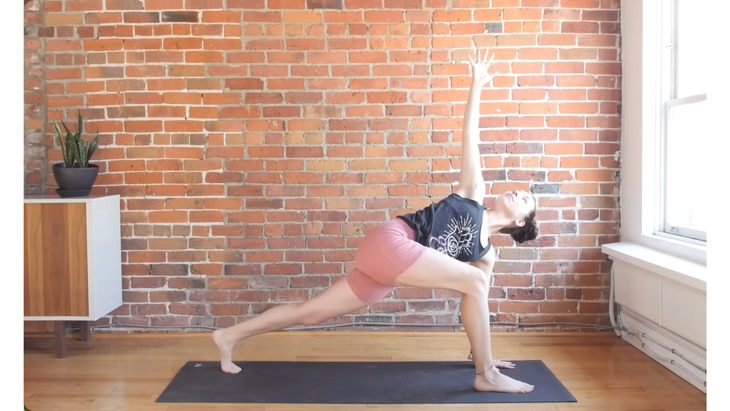 Woman in revolved lunge on a yoga mat