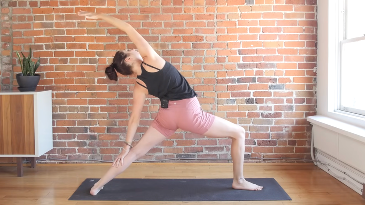 Woman on a yoga mat in Reverse Warrior