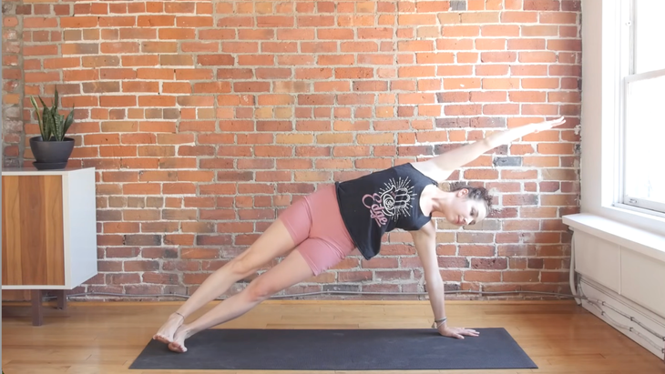 Side Plank Pose by a woman on a yoga mat