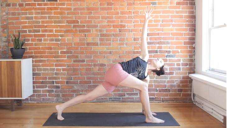 Woman in revolved lunge on a yoga mat