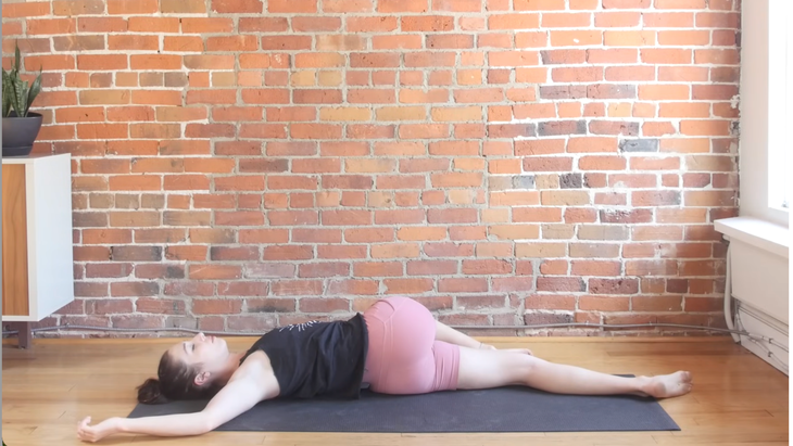 Woman on a yoga mat in a reclined twist