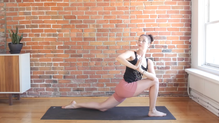 Woman in prayer twist on a yoga mat