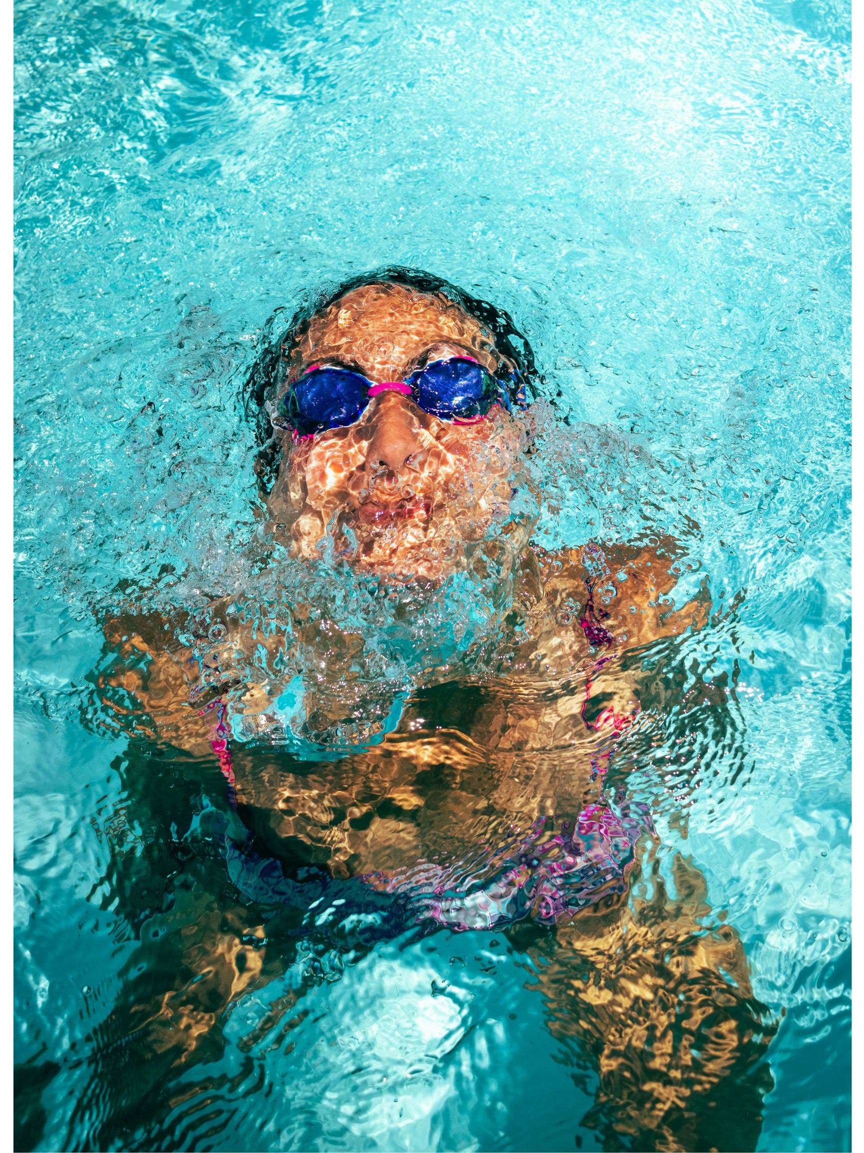 Woman wearing swimming goggles in a pool